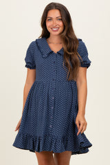 woman wearing a navy blue maternity dress with a collar, button-down front, and ruffled hem