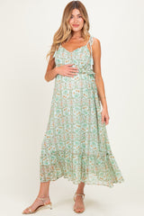 woman wearing a green floral maternity maxi dress with spaghetti straps and a baby bump visible