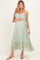 woman wearing a green floral maternity maxi dress with spaghetti straps and a baby bump visible