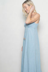 woman wearing a light blue maxi dress with adjustable straps and decorative beads