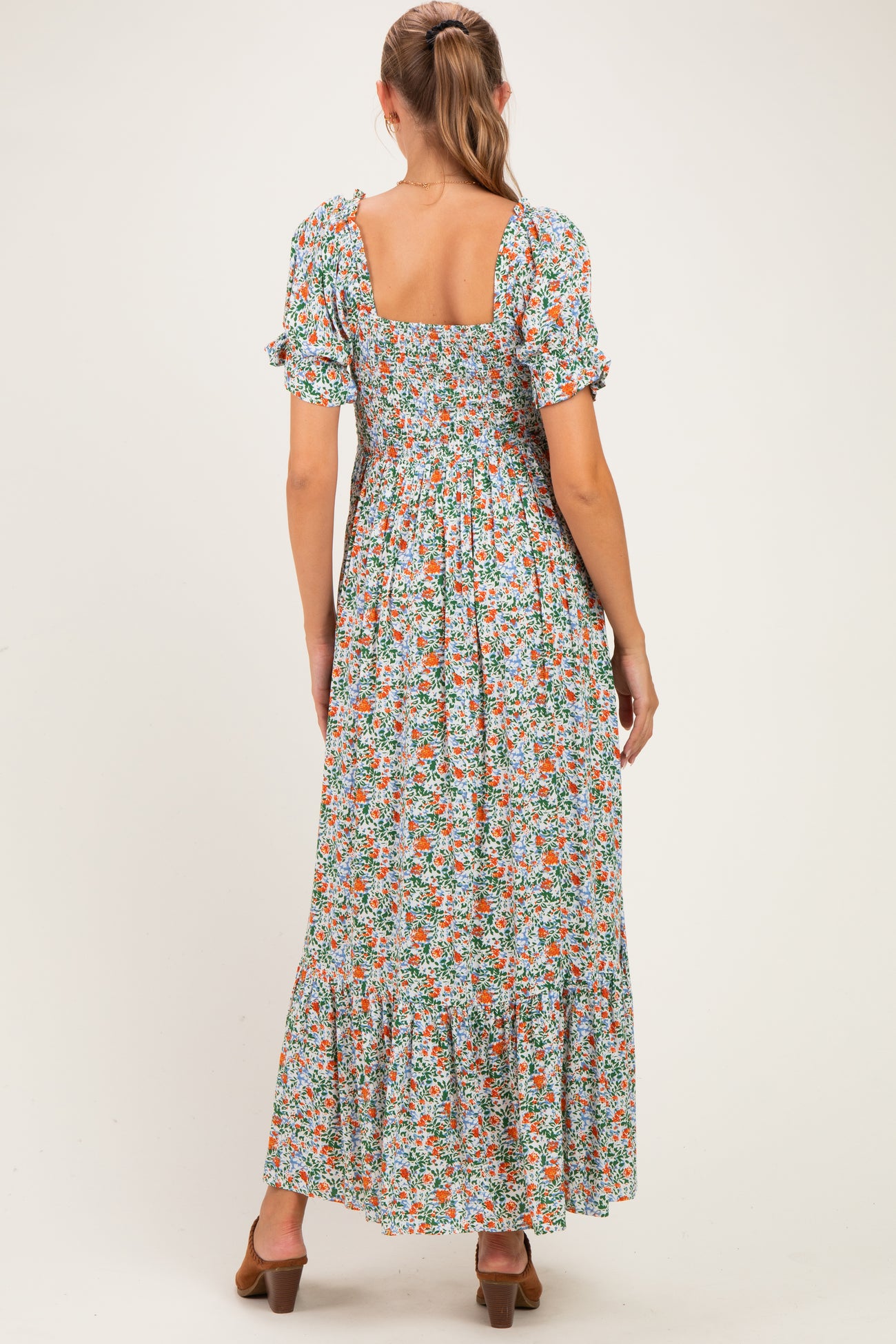 woman wearing a floral print maternity maxi dress with short puff sleeves and a square back