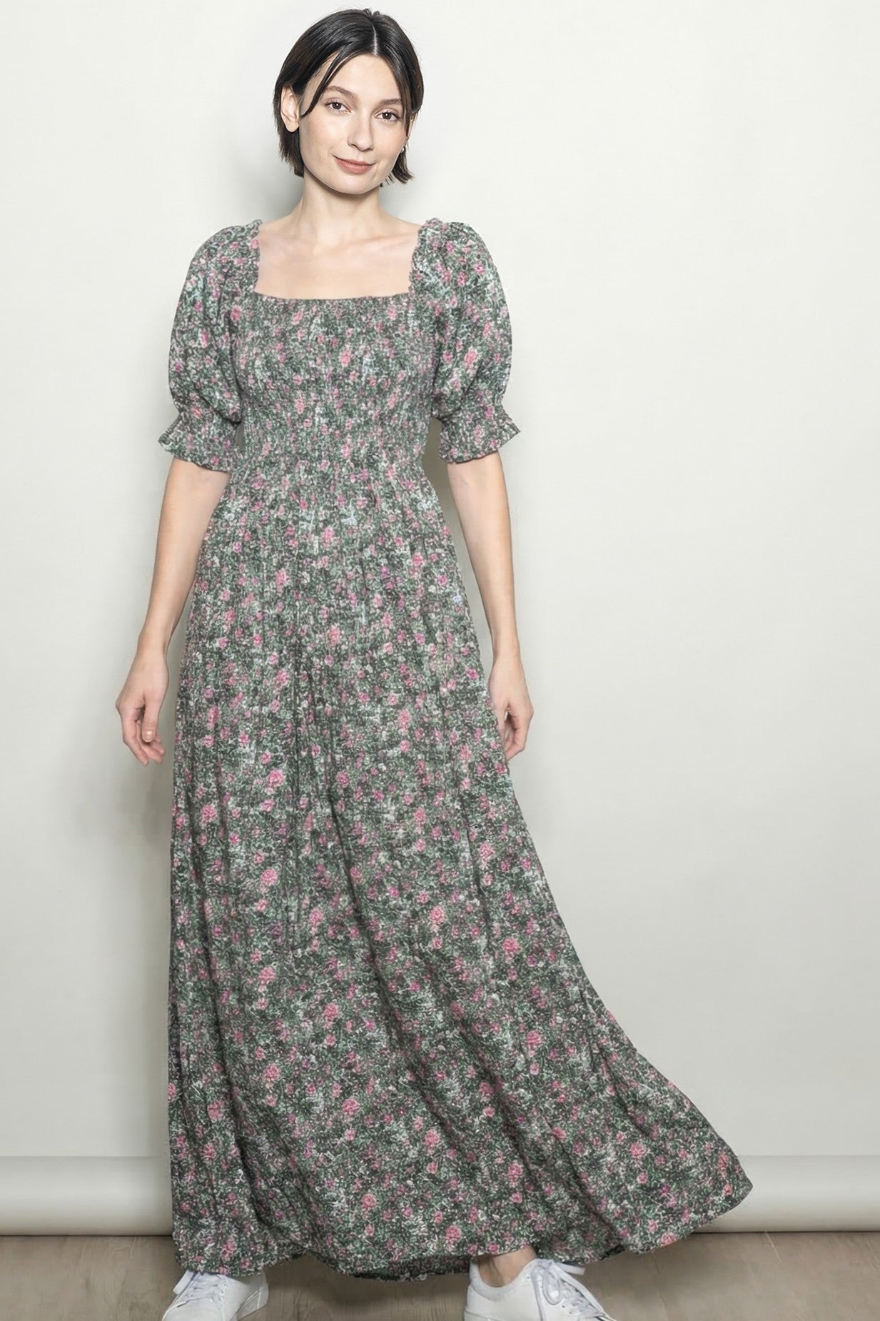 woman wearing a floral maxi dress with puff sleeves and a square neckline, standing against a neutral background