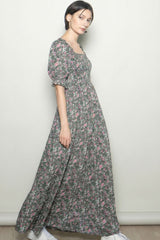 woman wearing a long floral maxi dress with puff sleeves and a square neckline, standing against a neutral background