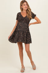 woman wearing a black floral maternity dress with short sleeves and a flared skirt, showcasing a baby bump