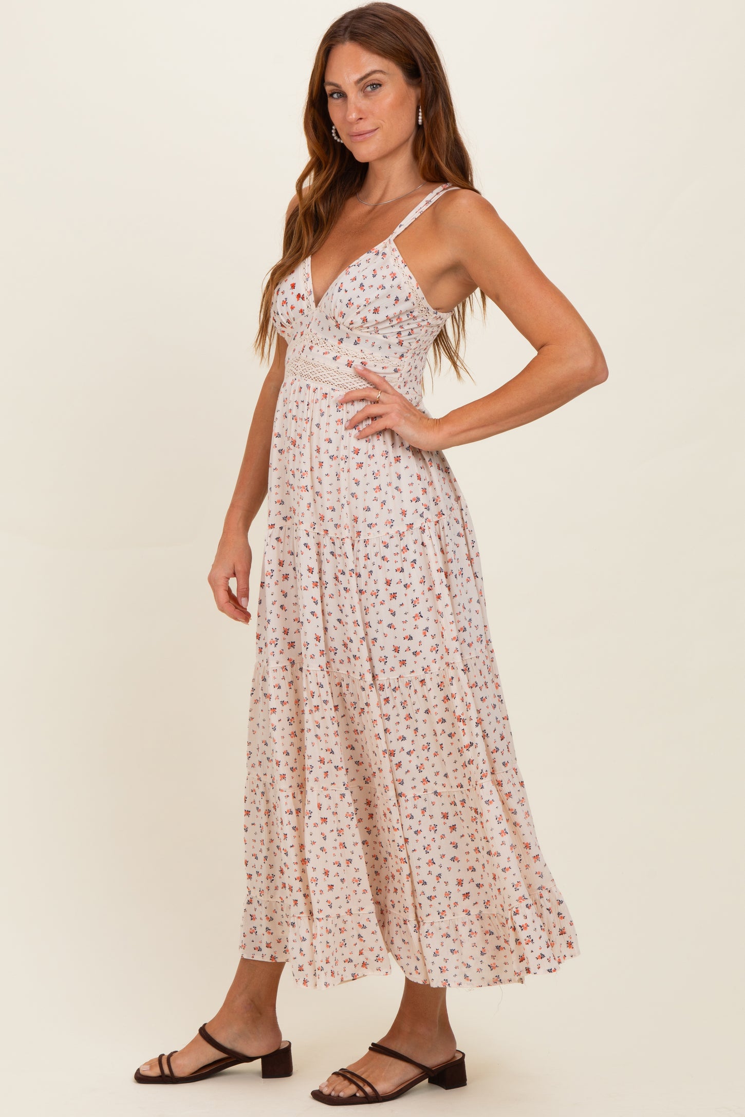 woman wearing a floral print maxi dress with a v-neckline and spaghetti straps