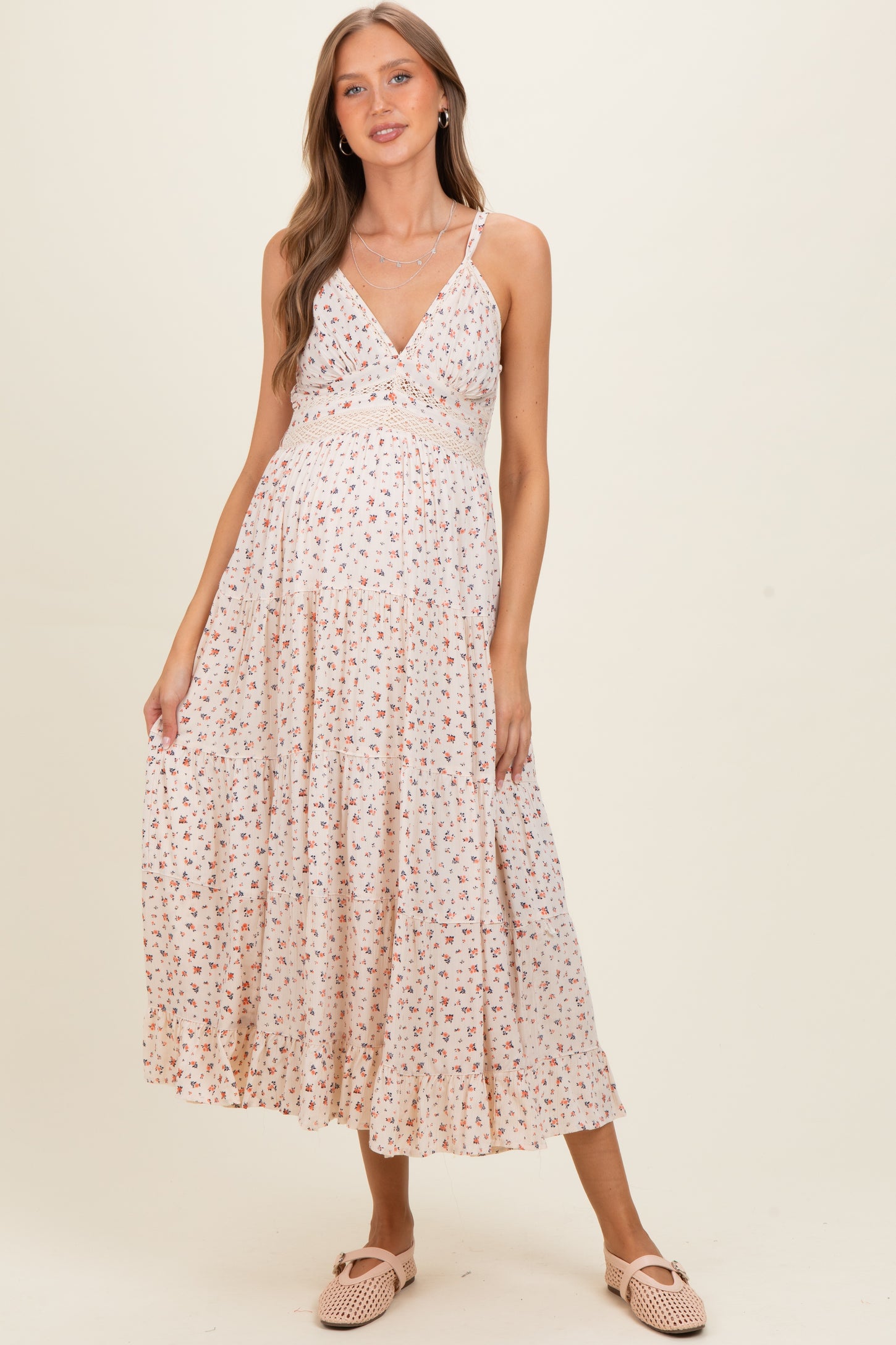 woman wearing a floral print maternity maxi dress with a v-neckline and a baby bump visible