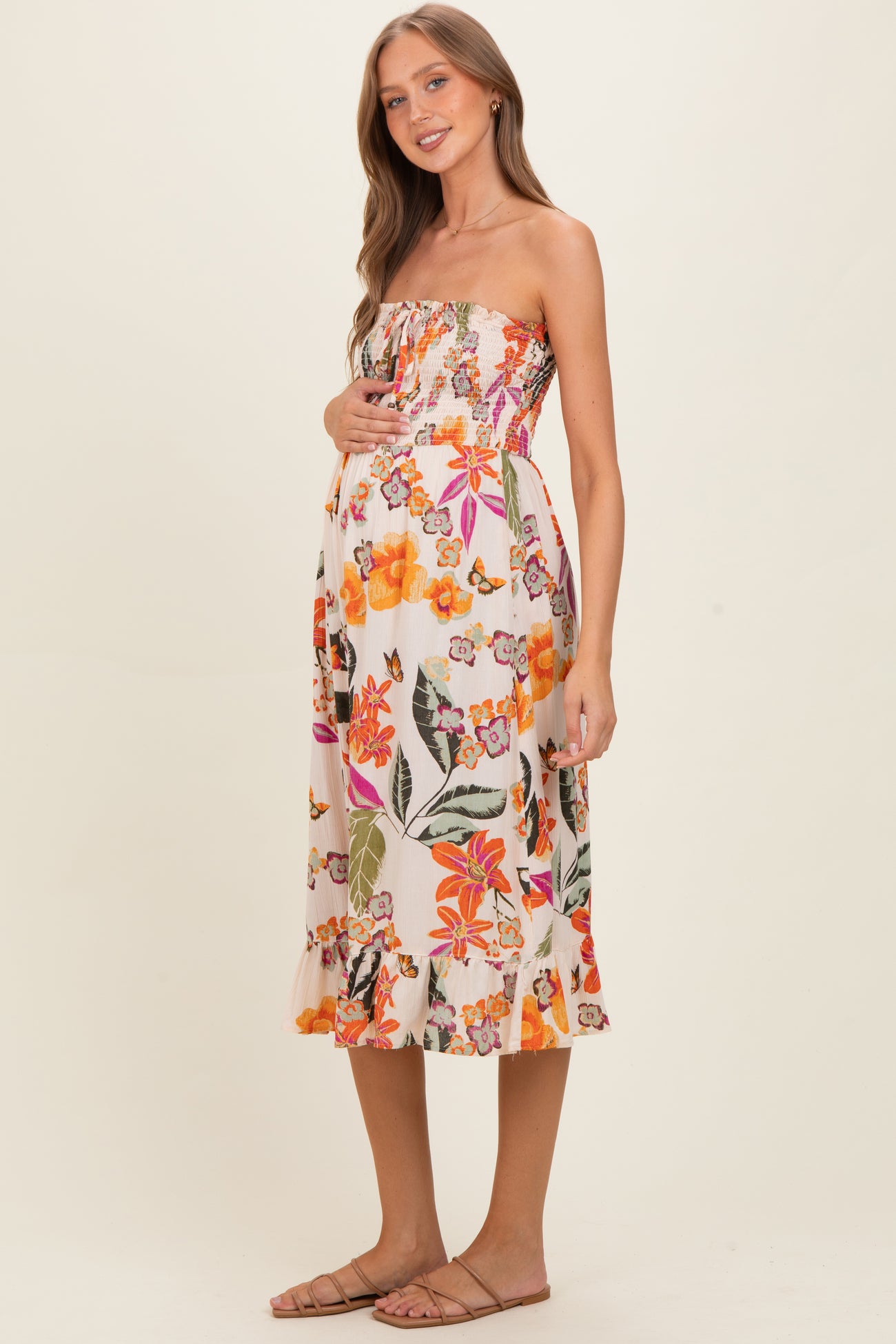 woman wearing a floral strapless maternity dress with a baby bump