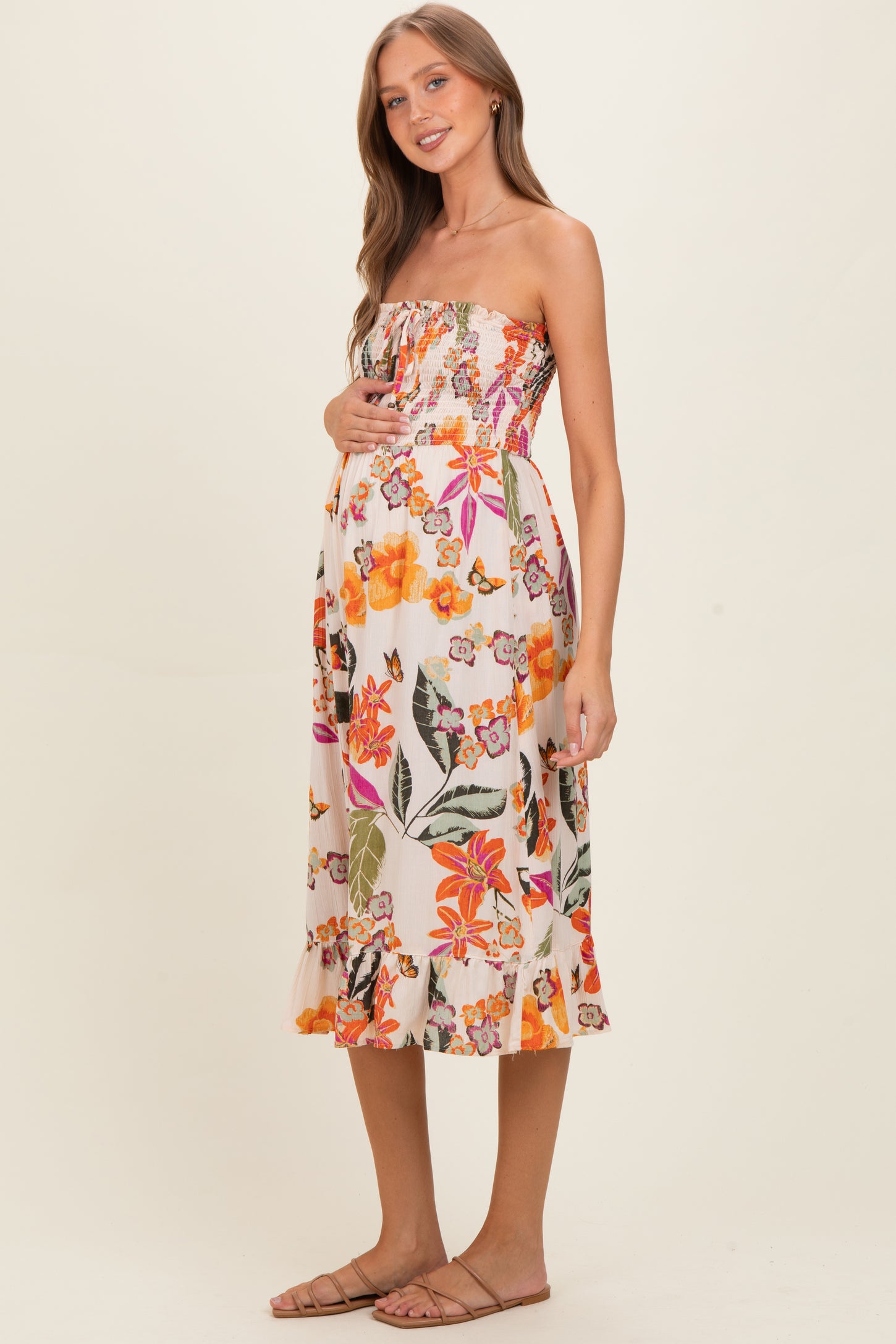 woman wearing a floral strapless maternity dress with a baby bump