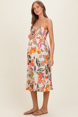 woman wearing a floral strapless maternity dress with a baby bump