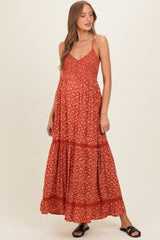 woman wearing a red floral maternity maxi dress with a ruffled hem and adjustable straps, showcasing her baby bump