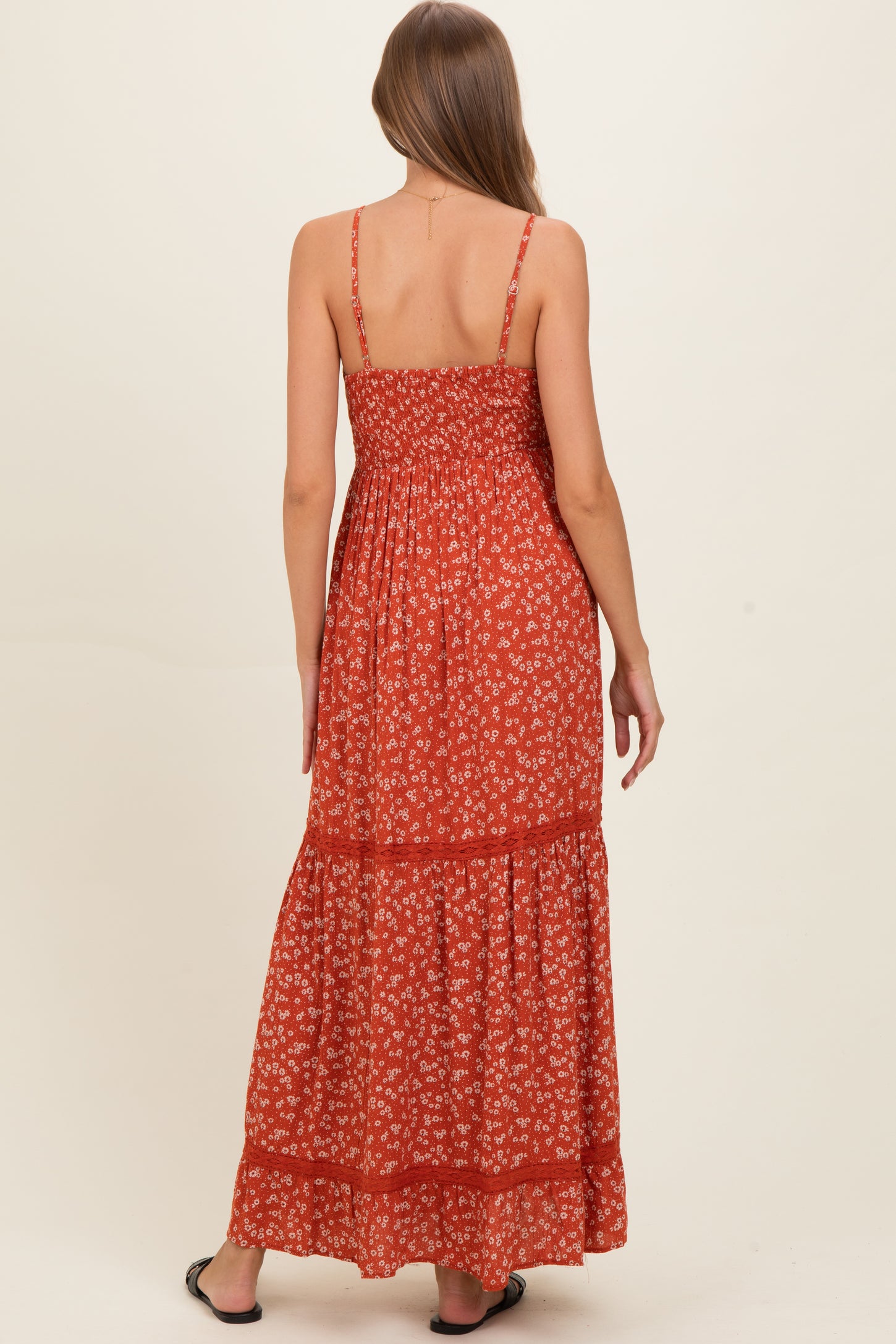 woman wearing a red floral maternity maxi dress with adjustable straps and smocked back detail