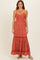 woman wearing a rust floral maxi dress with adjustable straps and a tiered skirt
