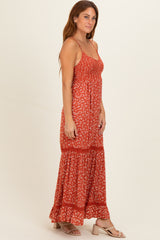 woman wearing a red floral maxi dress with a tiered skirt and adjustable spaghetti straps