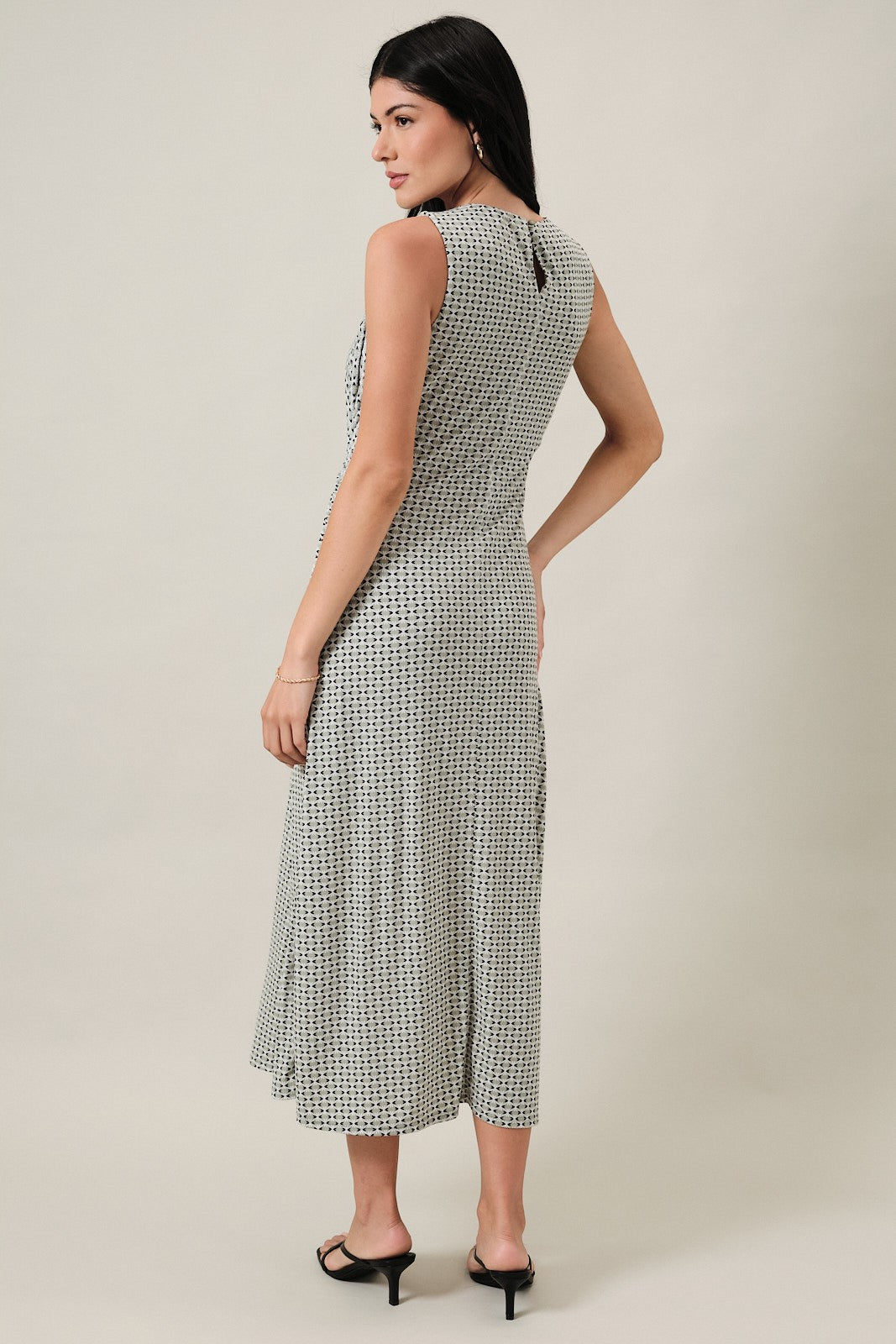 woman wearing a sleeveless black and white patterned midi dress, shown from the back