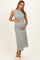 woman wearing a sleeveless black and white patterned maternity dress and holding her baby bump