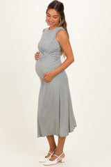 woman wearing a black and white patterned maternity dress and holding her baby bump