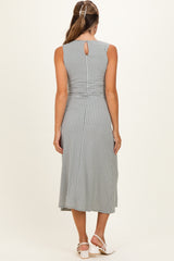 woman wearing a patterned sleeveless maternity dress with a keyhole back detail, showing her silhouette from behind