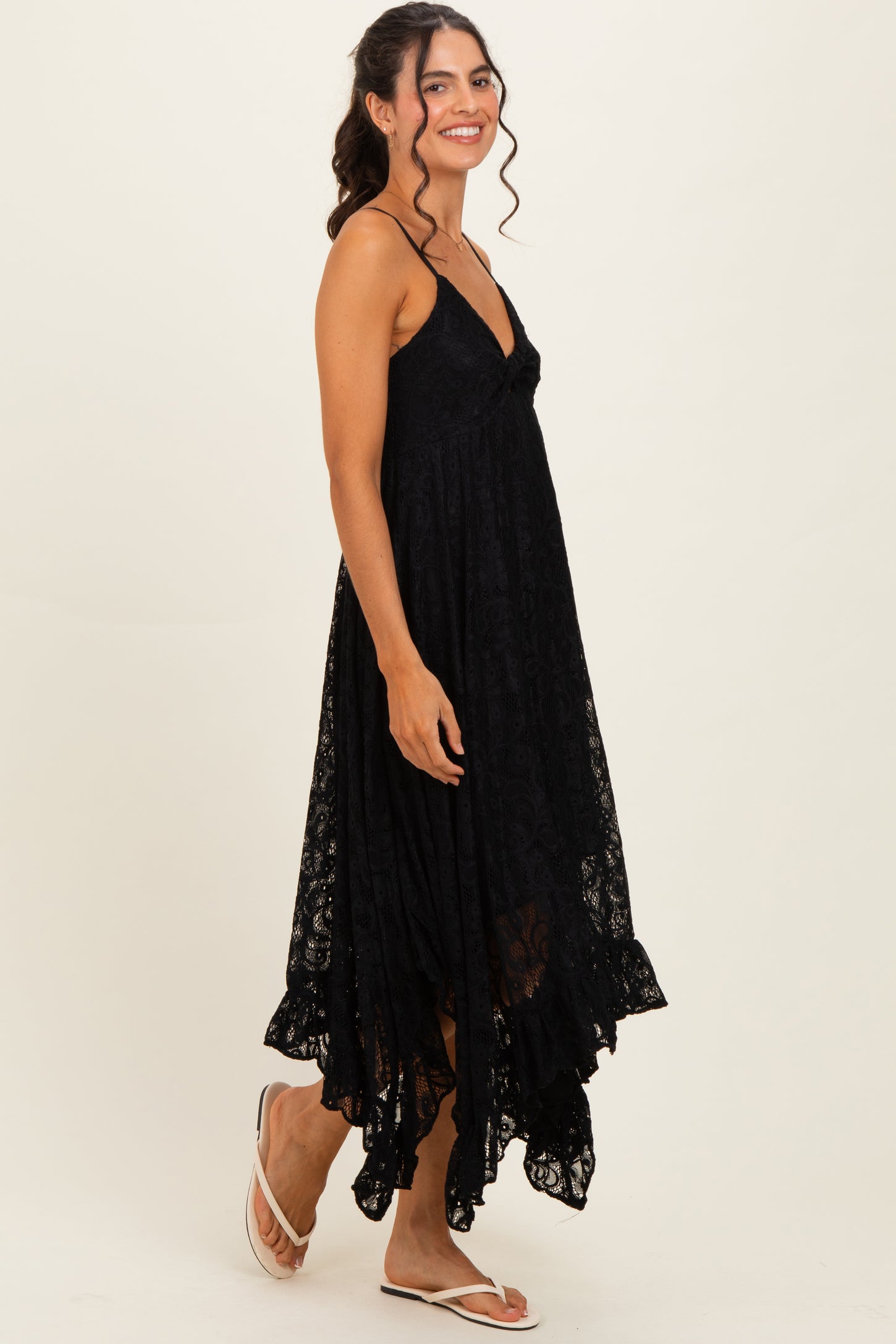 woman wearing a black lace maxi dress with a high-low hemline and spaghetti straps