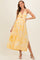 woman wearing a yellow floral print maternity maxi dress with a cutout detail and side slit