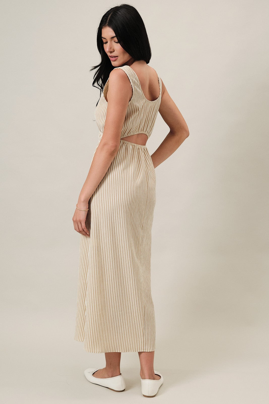 woman wearing a beige and white striped maxi dress with a back cutout and a relaxed fit