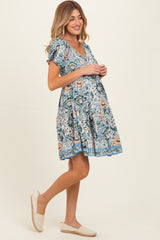 woman wearing a floral print maternity dress with short sleeves and a v-neck, showing her baby bump