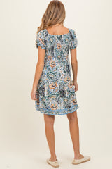 woman wearing a maternity floral short dress with puff sleeves and a relaxed fit, seen from the back