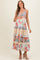 woman wearing a floral print maternity maxi dress with tiered ruffles and holding her baby bump