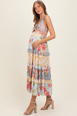woman wearing a floral maternity maxi dress with ruffles and a visible baby bump