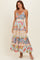 woman wearing a floral tiered maxi dress with adjustable spaghetti straps and a v-neckline