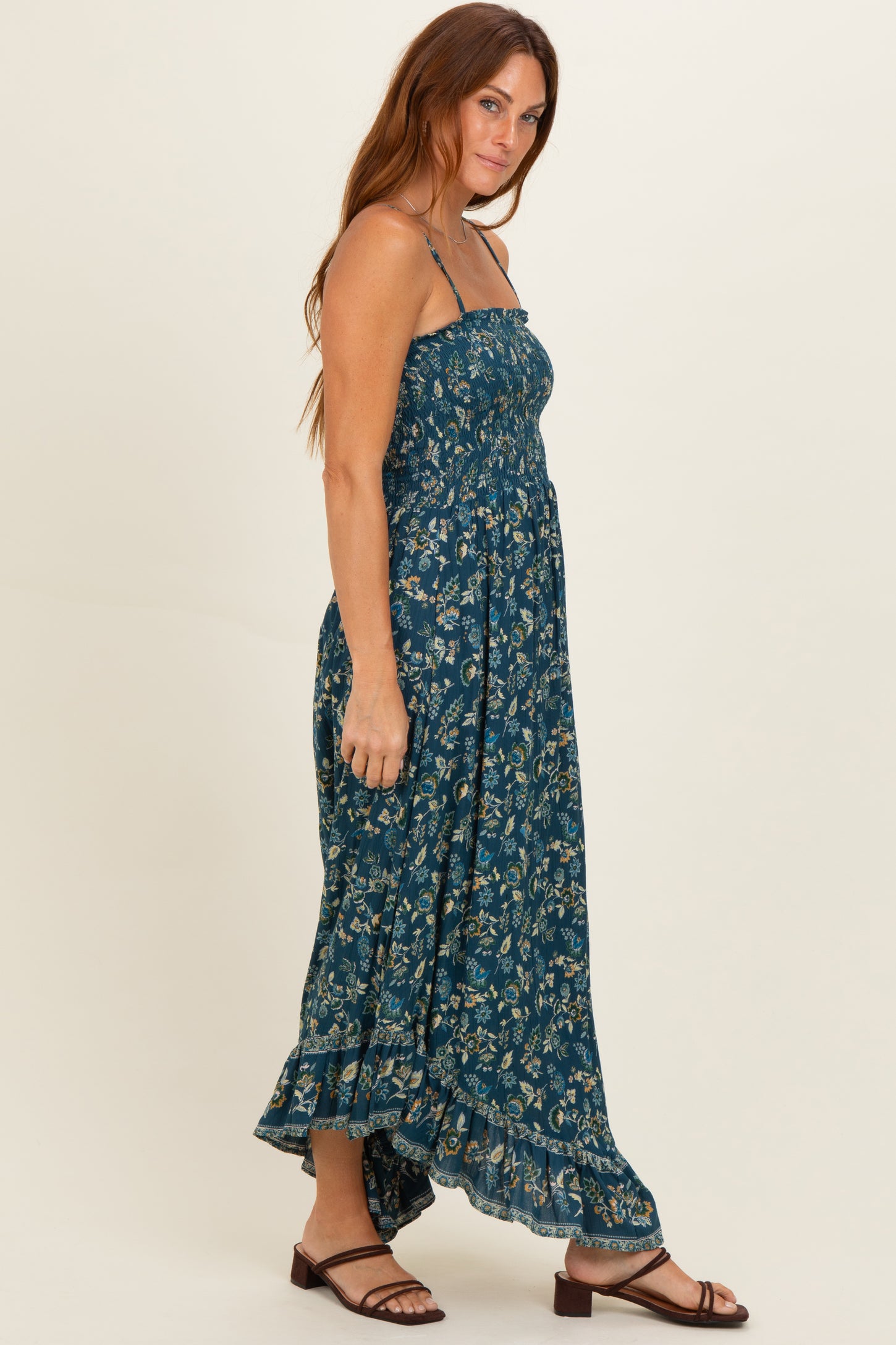 woman wearing a dark teal floral maxi dress with a smocked bodice and adjustable straps