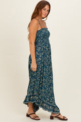 woman wearing a dark teal floral maxi dress with a smocked bodice and adjustable straps