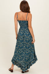 woman wearing a dark teal floral maxi dress with adjustable straps and a ruffled hem, showing the back view