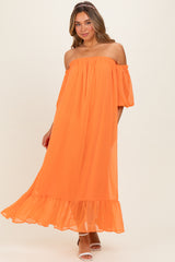 woman wearing an off-the-shoulder bright orange maxi dress with flutter sleeves and a ruffled hem