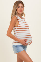 woman wearing a cream and rust striped maternity tank top and showing her baby bump while standing sideways