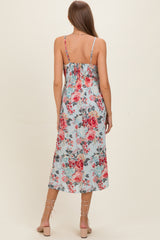 woman wearing a floral print maternity dress with a smocked back and adjustable straps, featuring a mid-length flowy skirt