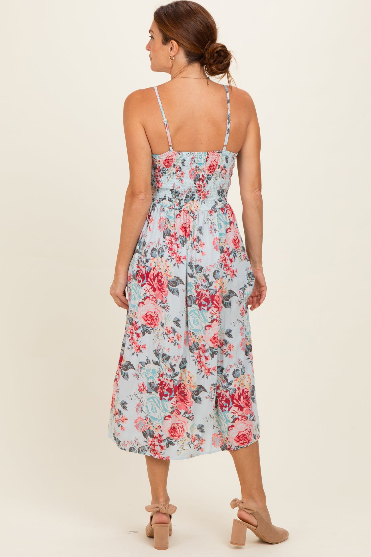 woman wearing a blue floral midi dress with a smocked back and thin straps
