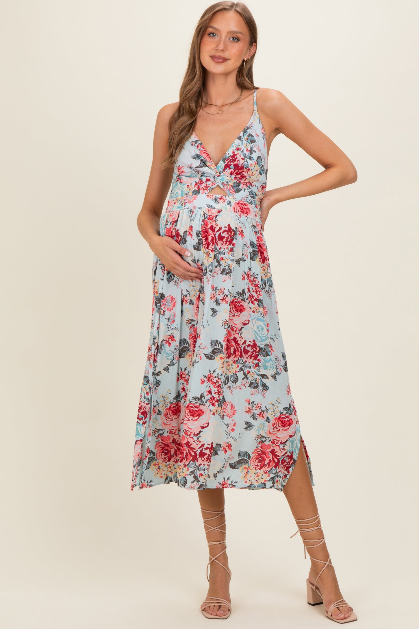 woman wearing a light blue floral maternity dress with a v-neckline and baby bump visible