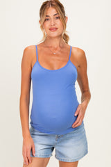 woman wearing a blue maternity tank top and showing her baby bump, paired with denim shorts