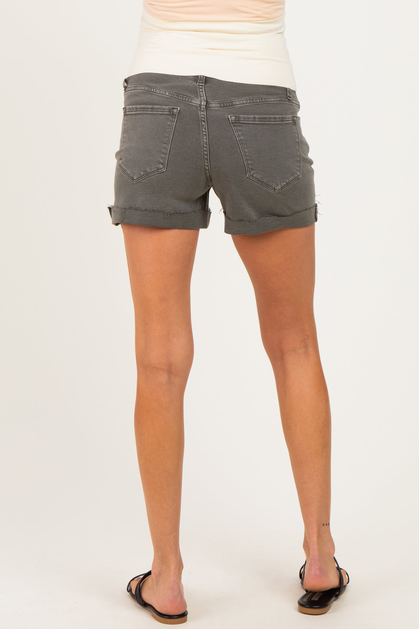 woman wearing gray maternity denim shorts, showing the back view with a relaxed fit and rolled hem
