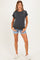 woman wearing a dark gray maternity t-shirt and denim shorts, showcasing her baby bump