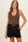 woman wearing a brown ribbed maternity tank top and black maternity shorts with leopard print drawstring