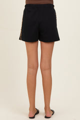woman wearing black maternity shorts with leopard print side panel, showing the back view