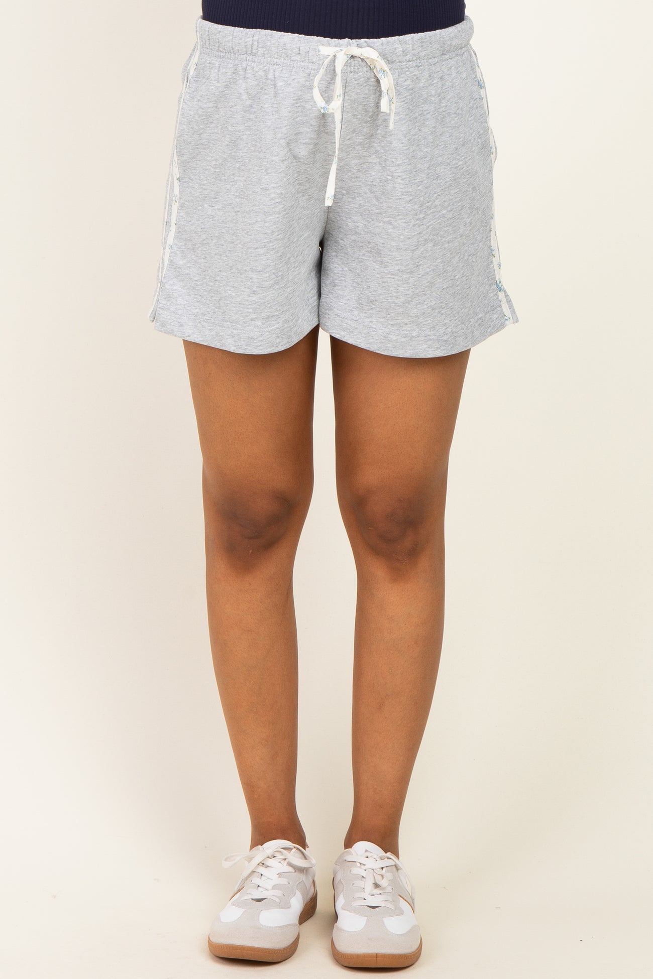 woman wearing gray maternity shorts with a drawstring waistband and side tape details