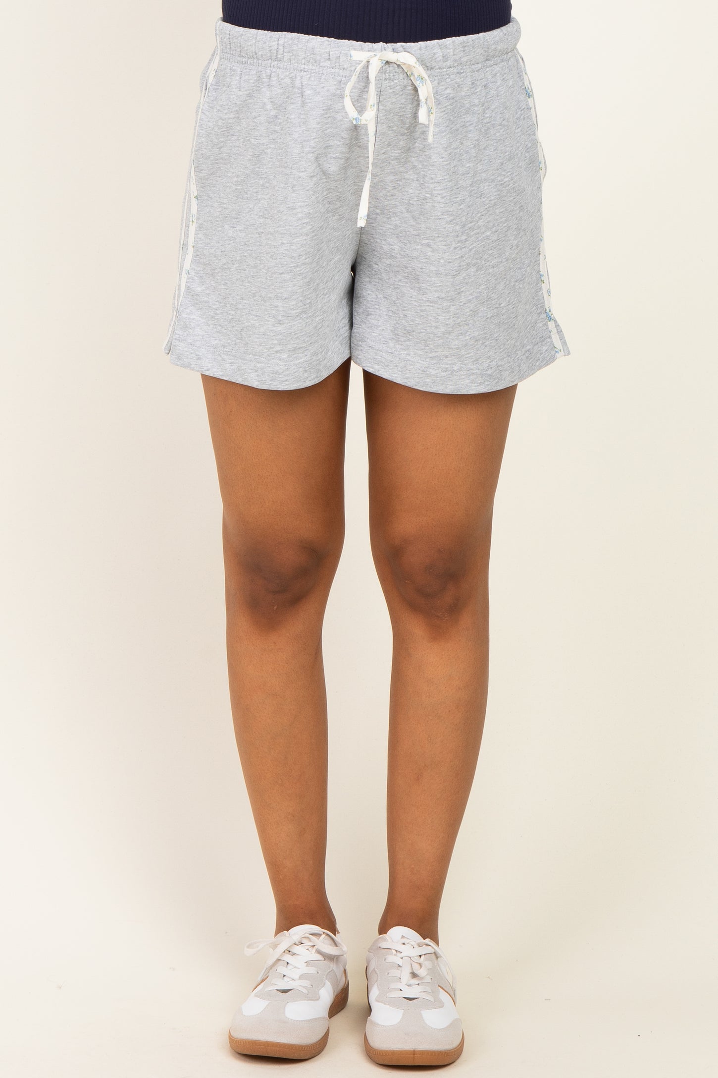 woman wearing gray maternity shorts with a drawstring waistband and side tape details