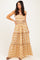 woman wearing a strapless orange and white floral maxi dress with tiered layers and a tie belt