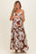 woman wearing a brown floral maternity maxi dress and cradling her baby bump