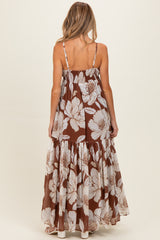 woman wearing a brown floral print maternity maxi dress with a tiered skirt and adjustable straps, showing her baby bump