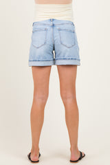 woman wearing light wash maternity denim shorts with rolled cuffs, showing the back view