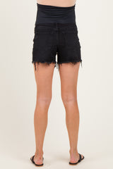 woman wearing black maternity denim shorts with frayed hem and an elastic waistband, viewed from the back