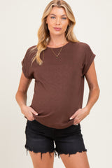 woman wearing a brown short sleeve maternity top with a visible baby bump and black distressed shorts